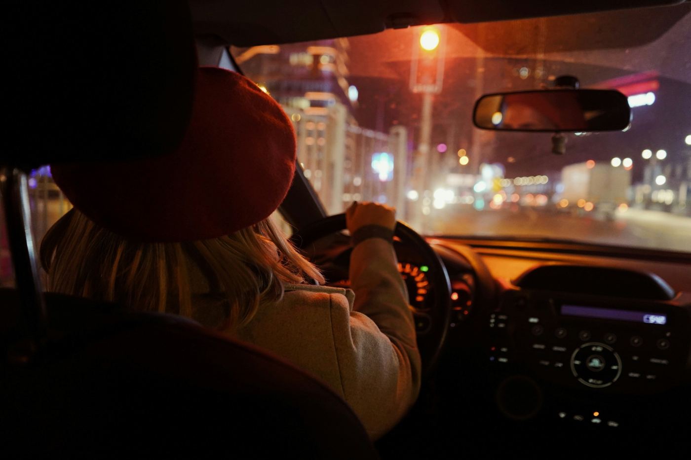 Condutora ao volante numa rua da cidade, à noite