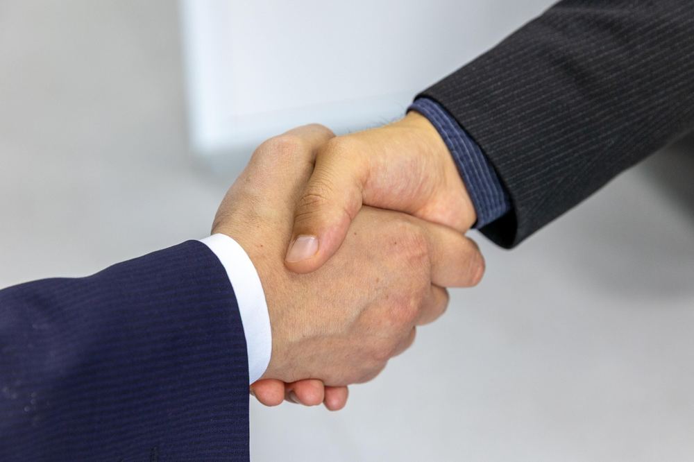 Aperto de mão entre parceiros, simbolizando confiança